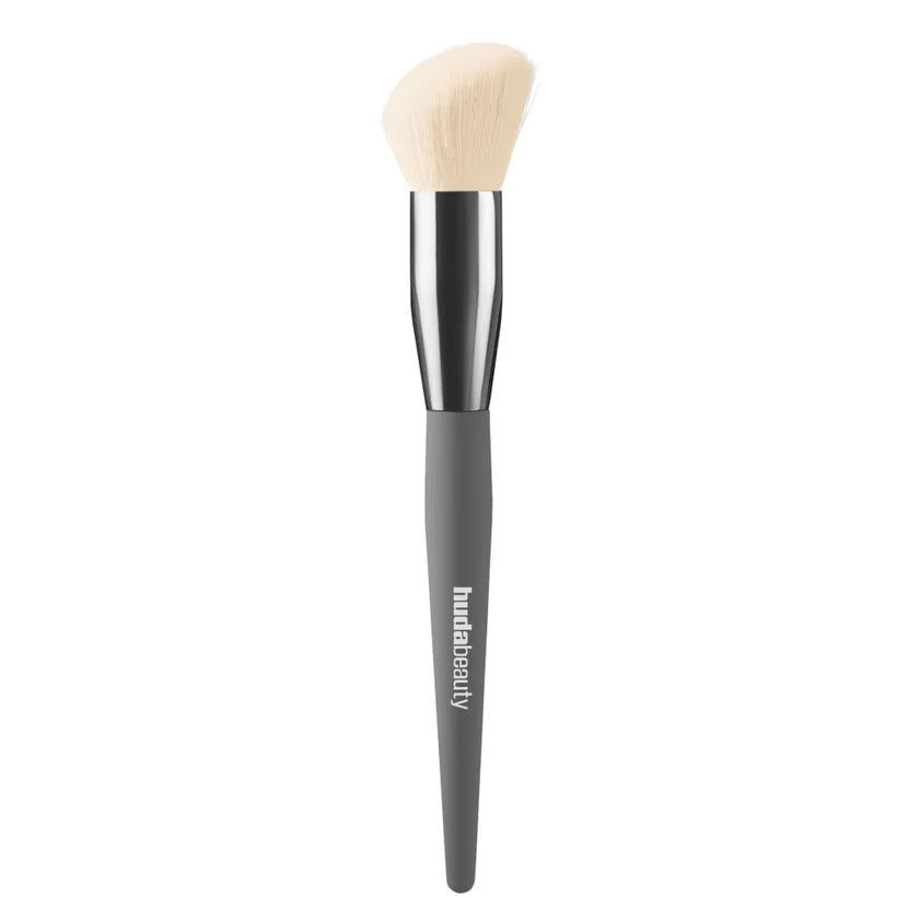 HUDA BEAUTY Diffusing Cheek Brush fluffy angled makeup brush with black handle and dense bristles
