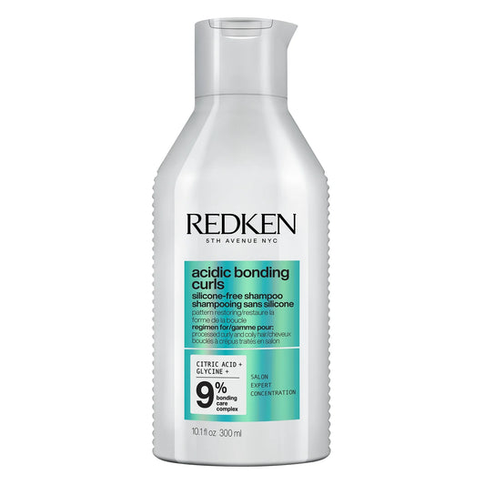 Redken Acidic Bonding Concentrate Curls silicone-free shampoo in a matching curved bottle, front label calling out care for damaged curls and coils.